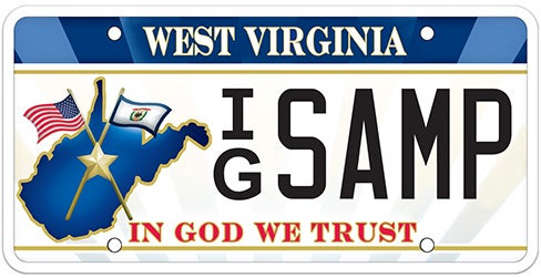 A West Virginia specialty license plate featuring a blue map outline of the state with crossed American and state flags on the left, the motto 'IN GOD WE TRUST' printed in red along the bottom, and sample registration IG SAMP