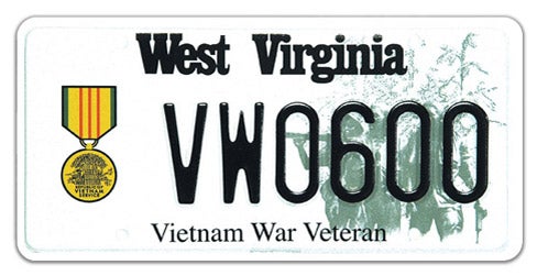 A West Virginia military specialty license plate honoring Vietnam War veterans, featuring the Vietnam Service Medal graphic on the left, a faded background image of soldiers in the field on the right, 'Vietnam War Veteran' printed along the bottom, and sample registration VW 0600